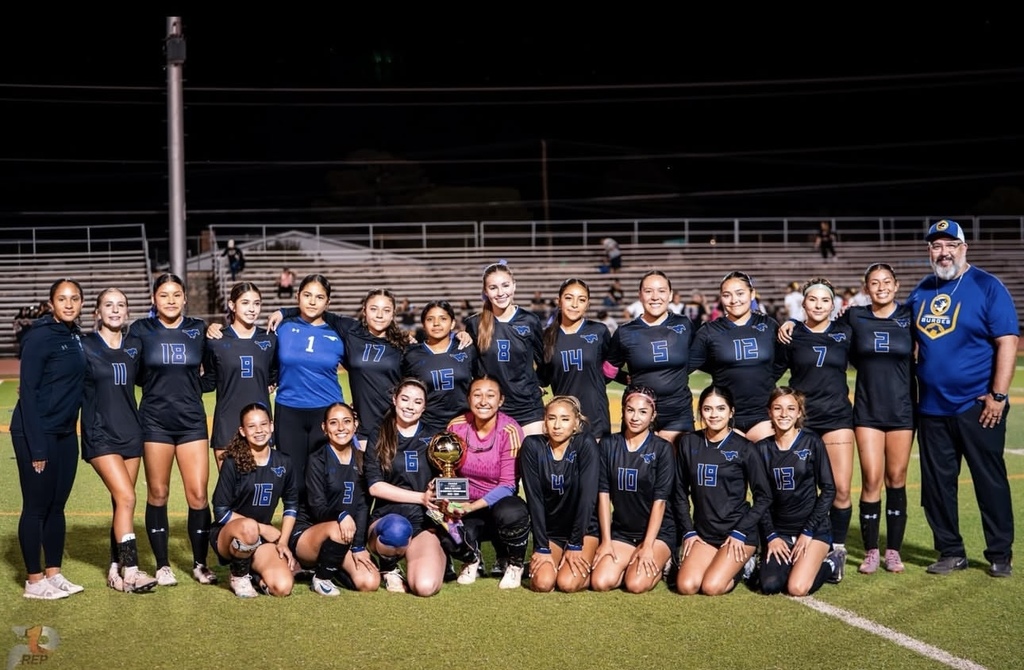 Group photo of the Burges High School Girls Soccer team with their Bi-District Champions Trophy