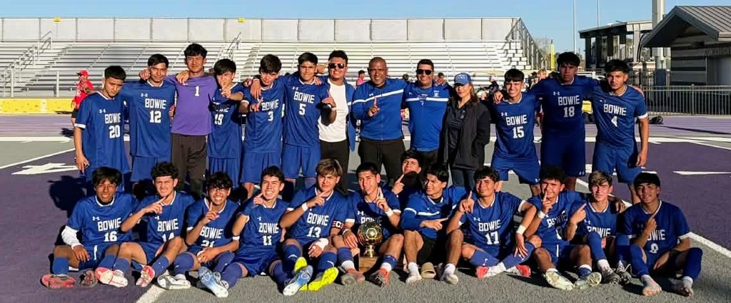 Group photo of the Bowie High School Boys Soccer team with their Bi-District Champions Trophy