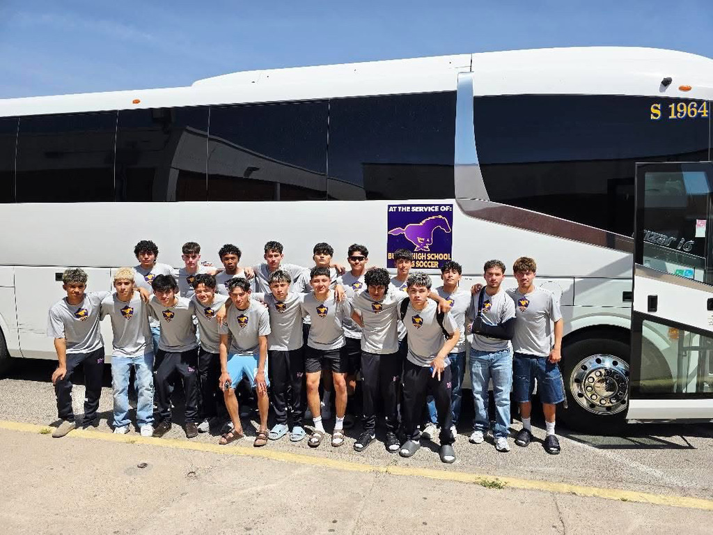 Burges High School boys soccer team takes group photo in front of bus
