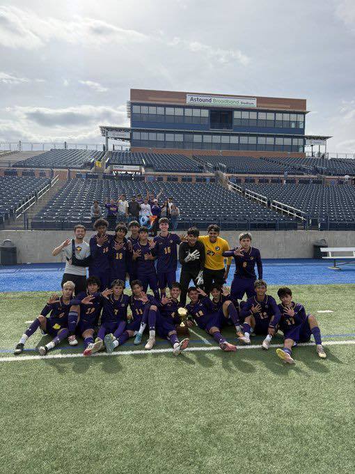 Burges High School varsity boys soccer team takes a group photo with their Regional Final trophy,