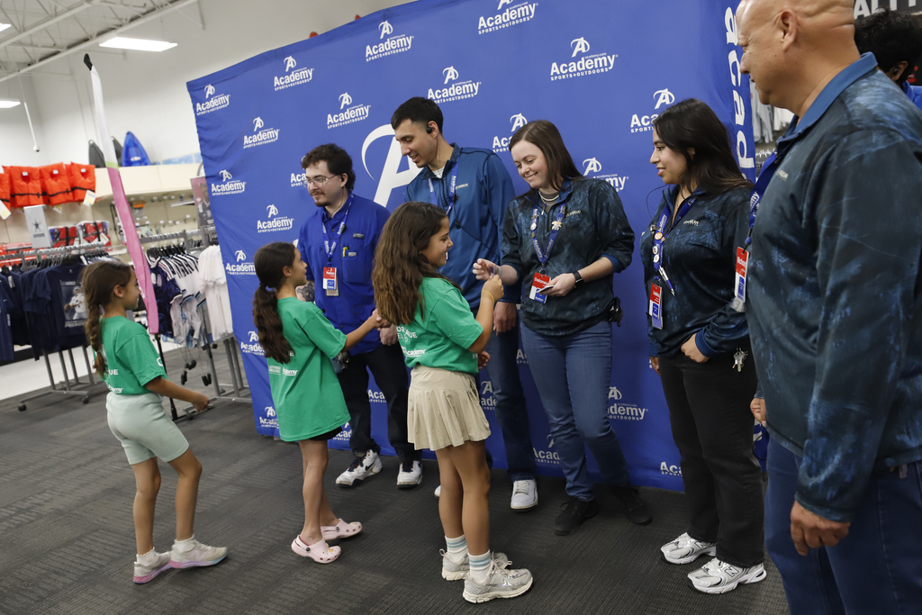 Mesita Elementary students who are part of Girls on the Run receive giftcards from Academy Sports + Outdoors staff