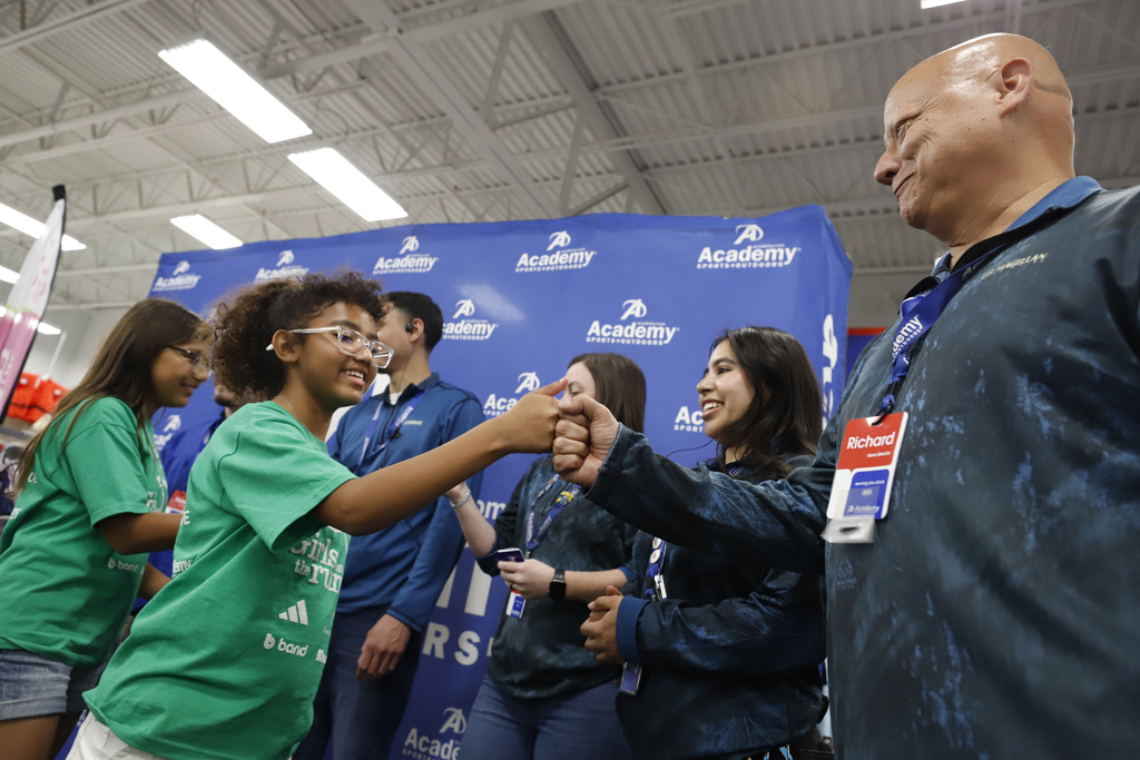 Mesita Elementary students who are part of Girls on the Run receive giftcards from Academy Sports + Outdoors staff