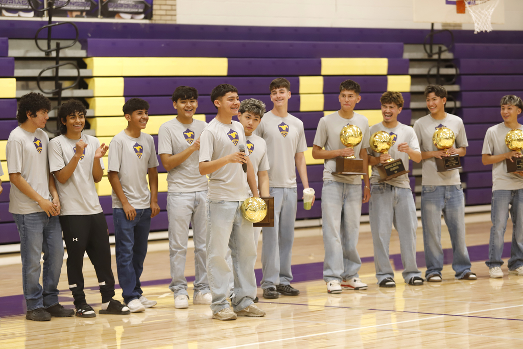 Burges High School soccer team player gives speech while teammates smile at him