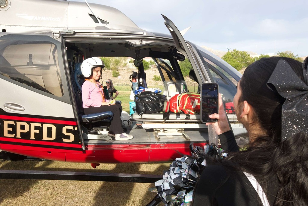 Franklin cheerleader takes photo of young child inside a helicopter