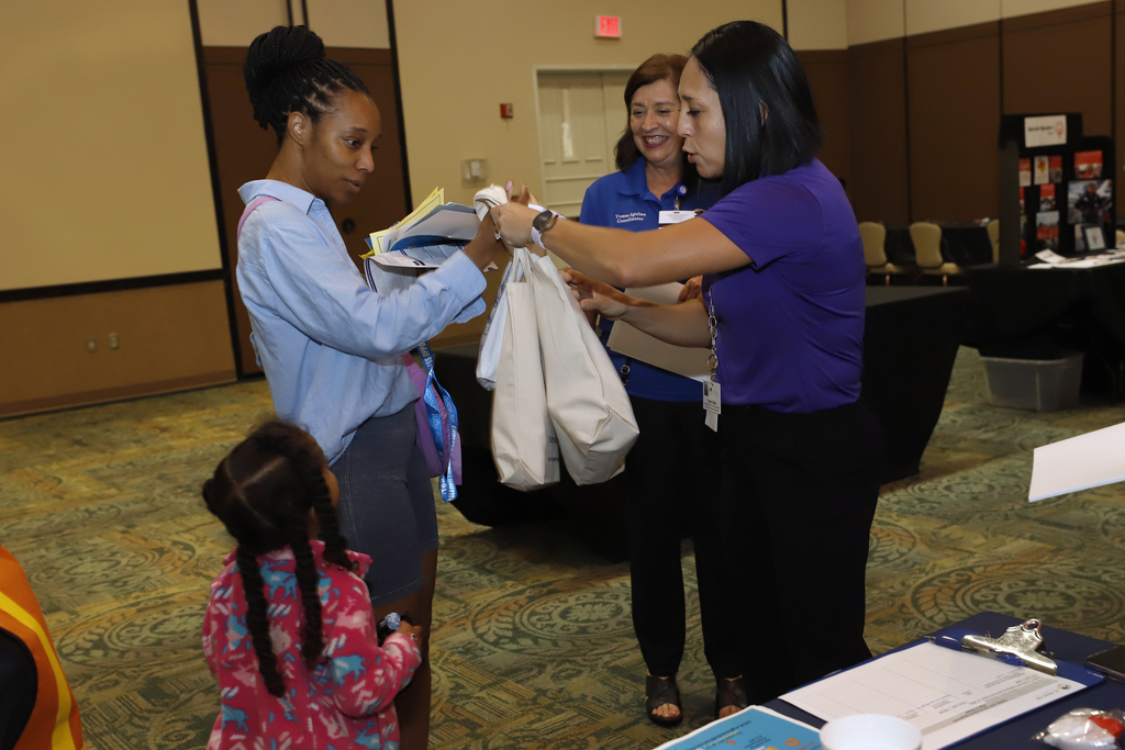 El Paso ISD staff member talks with community member while handing them bags
