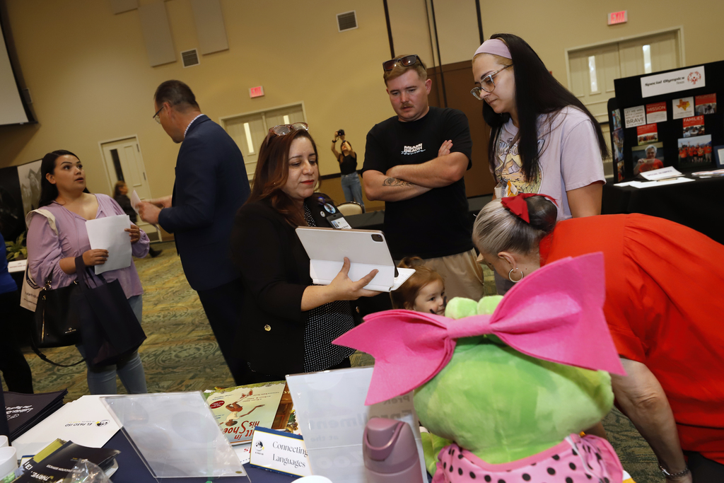 El Paso ISD staff member talks with community members showing information on ipad