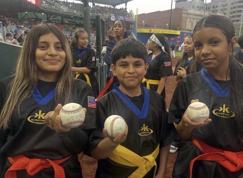 Three Bobby Joe Hill PK8 Kickstart kids take a group photo holding baseballs