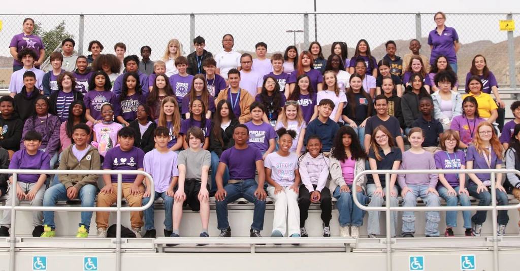 Large group of students from Navarrete Middle School smile for a photo showing off their purple attire for Purple Up Day