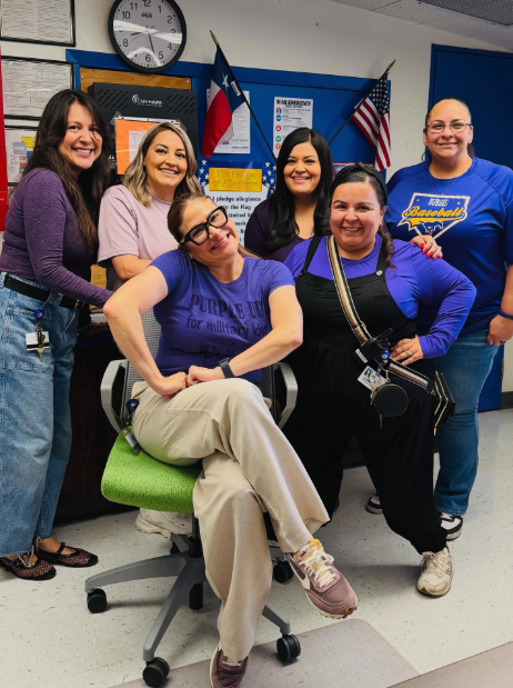 Staff members take group photo showing off their purple attire for Purple Up Day
