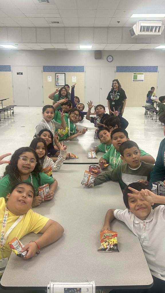 Students smile for camera in the cafeteria while eating Hot Cheetos with cheese
