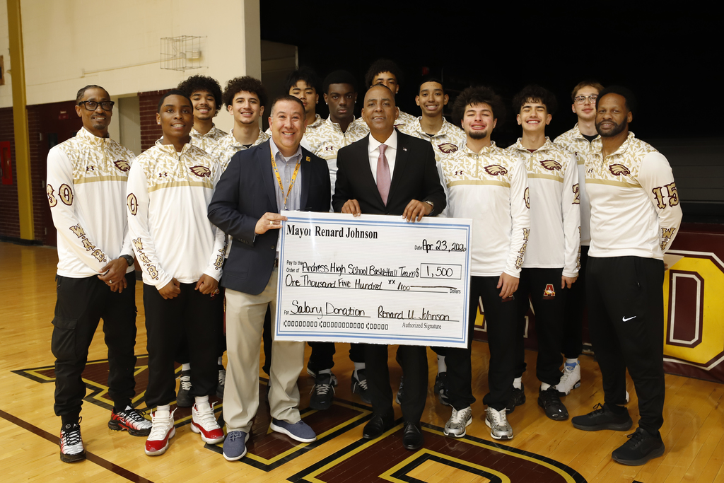 Mayor Renard Johnson takes group photo with the Andress High School boys basketball team, coaches, and Principal while holding giant check