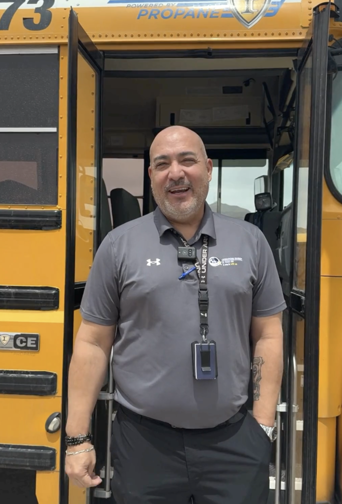 El Paso ISD staff member smiles in front of school bus