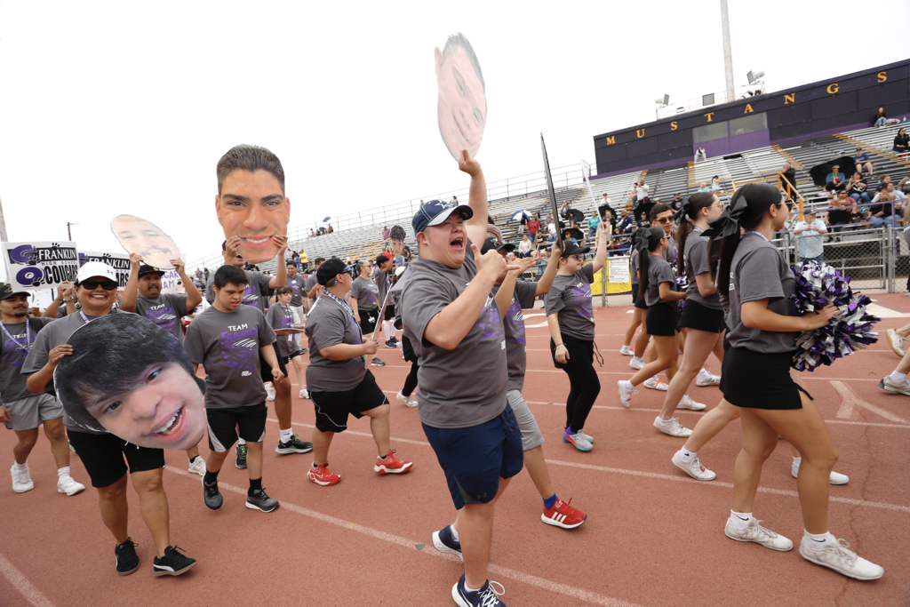 Franklin High School students walk on track during Unidos Games parade