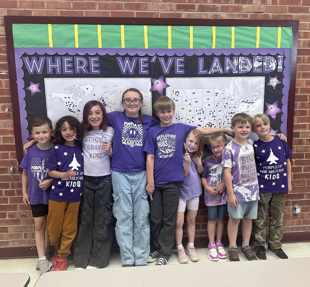 Student take a group photo wearing purple for Month of the Military Child