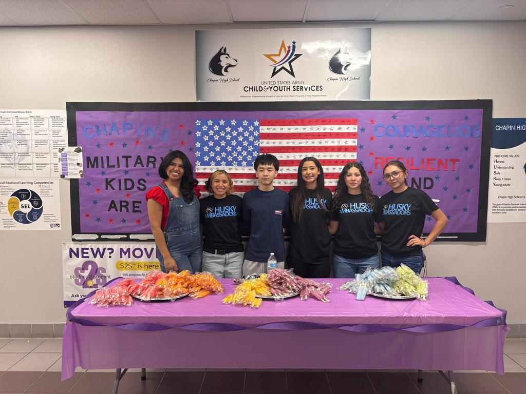 Student take a group photo before handing out popsicles to military students