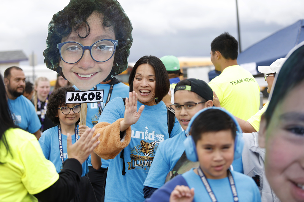 Unidos Game Parade staff member waving