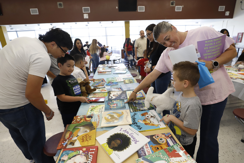Parent and students looking at books