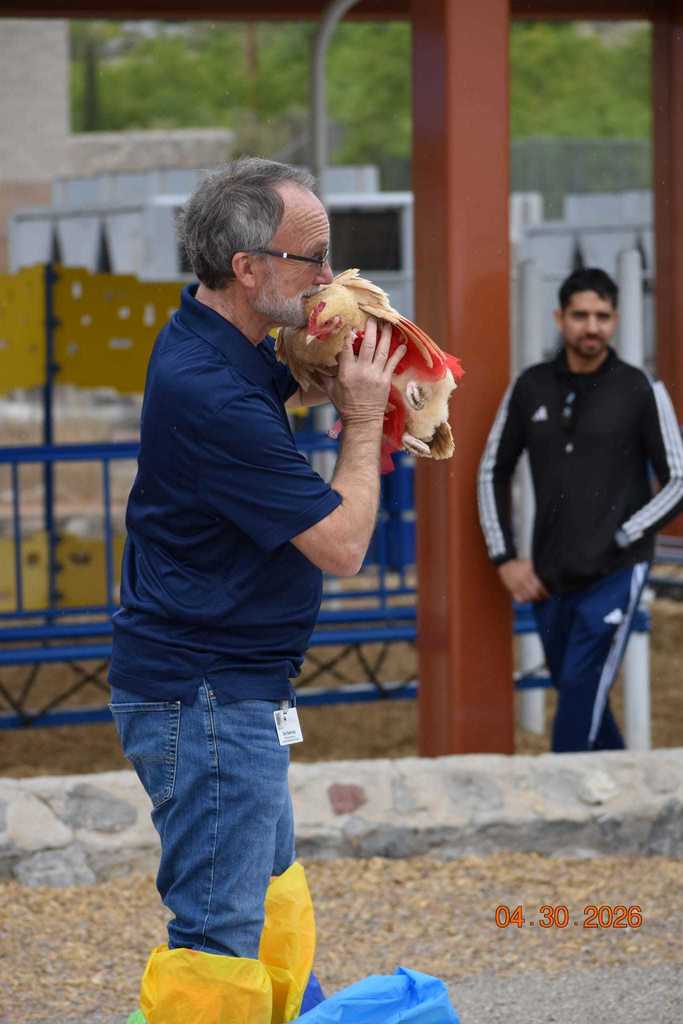 Principal Belknap kisses a chicken 