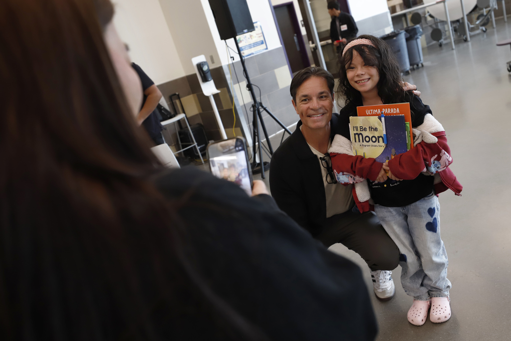 Person taking a photo of Author and student