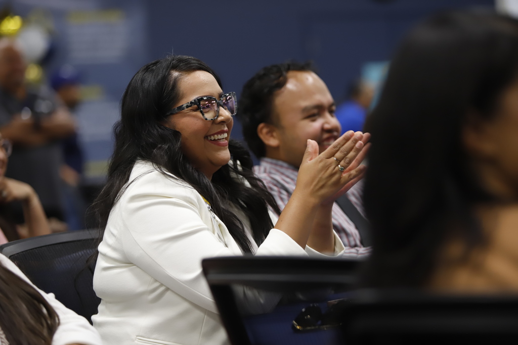Staff member smiles while clapping