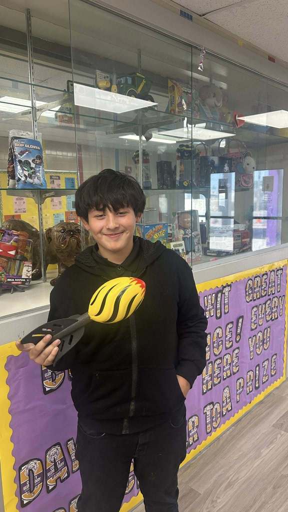 Students holds football toy as part of prize for perfect attendance