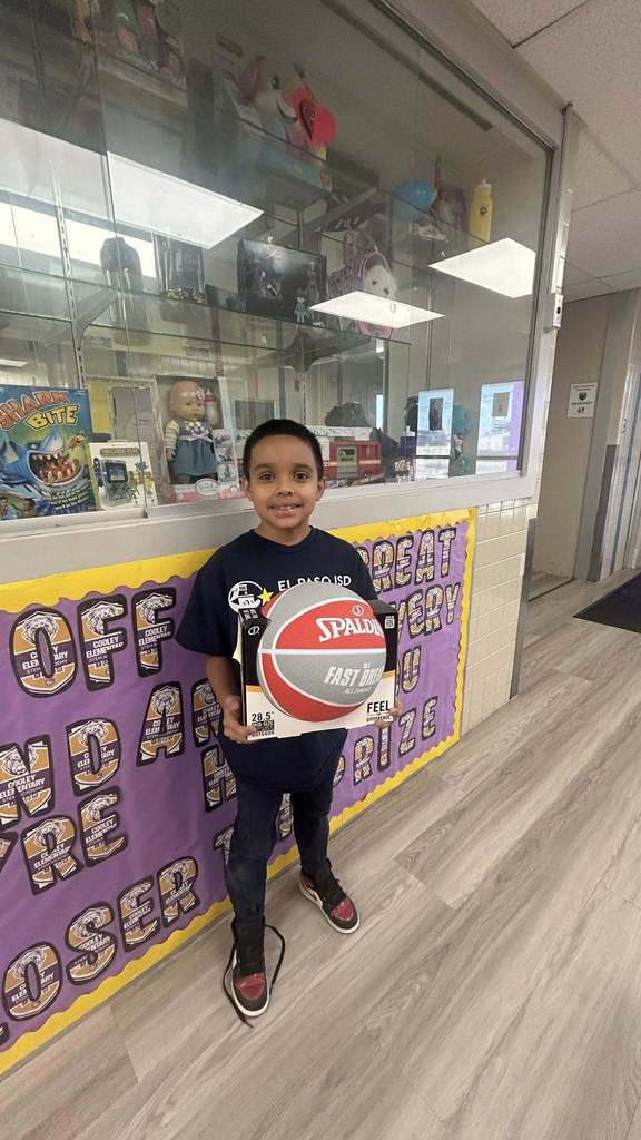 Students holds basketball as part of prize for perfect attendance