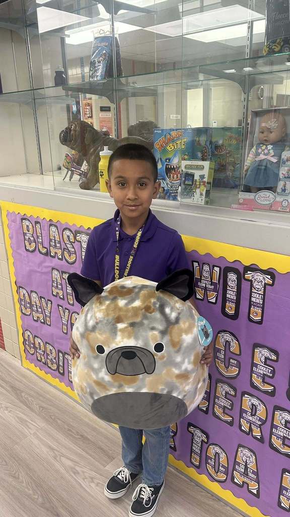 Students holds giant squishmellow as part of prize for perfect attendance