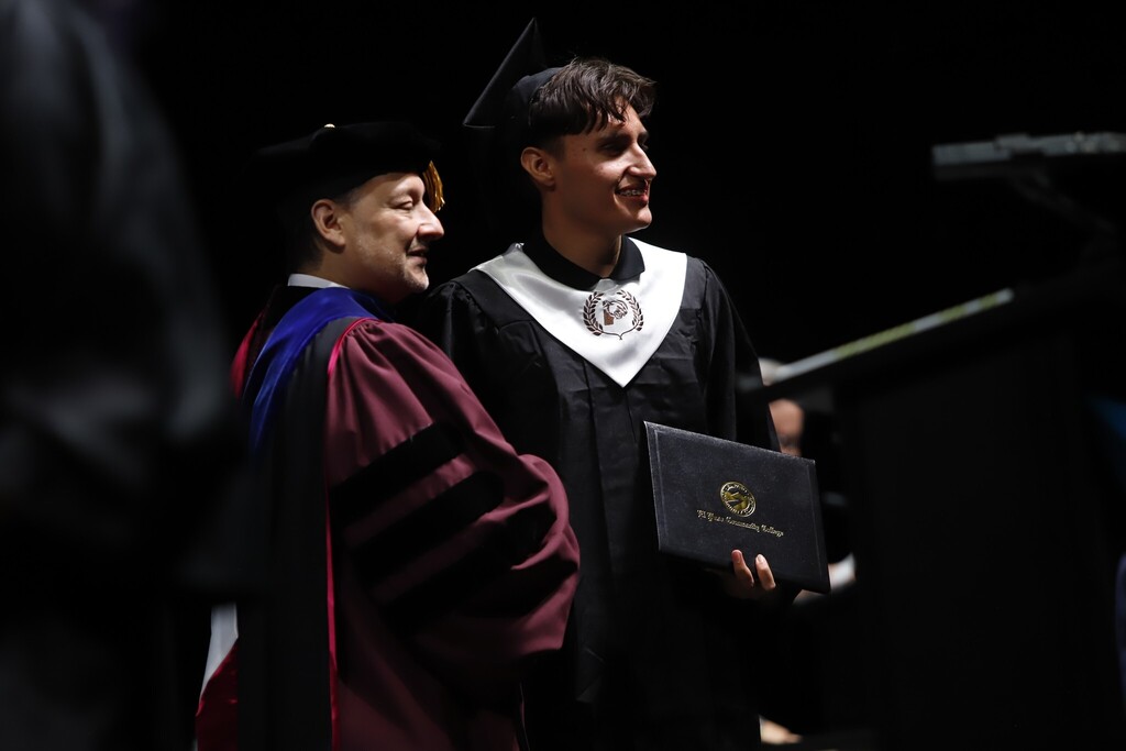 Austin High School P-TECH program graduate takes photo with EPCC president after receiving diploma