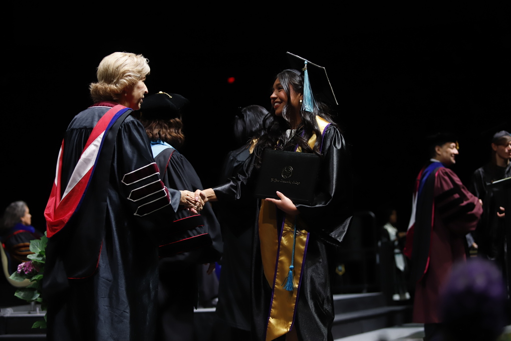 Burges High School student shakes hands with EPCC staff member after receiving diploma