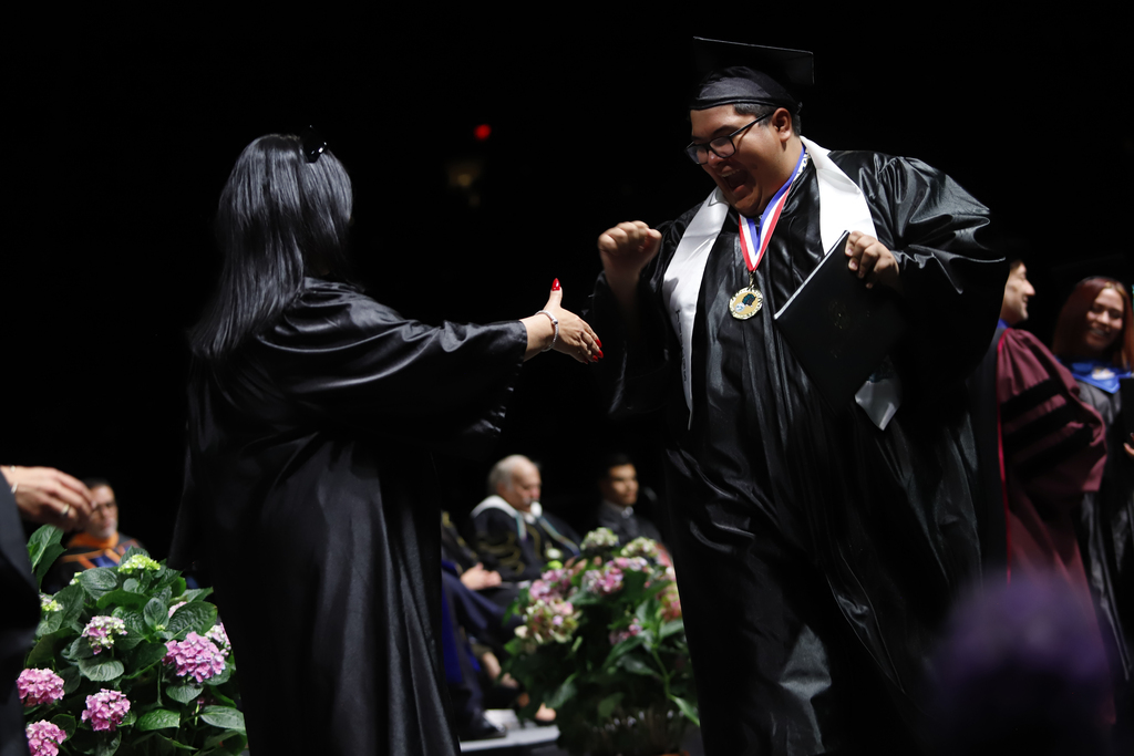 Transmountain Early College High School  students cheers after he receives diploma