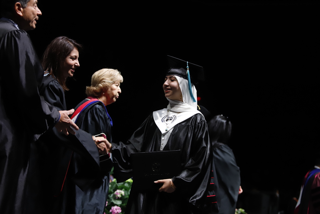 Coronado High School P-TECH student shakes EPCC staff members hand while after diploma