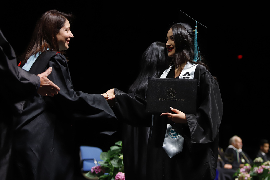 Jefferson High School student shakes hand with EPCC staff after receiving diploma