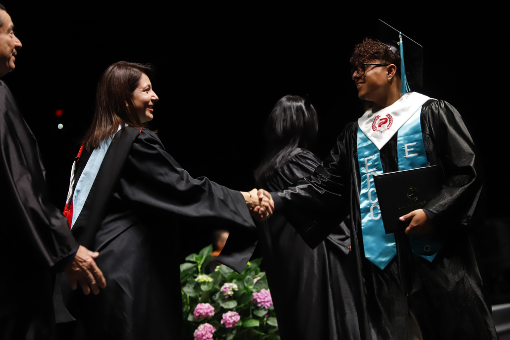 Irvin High School student shakes hand with EPCC staff after receiving diploma