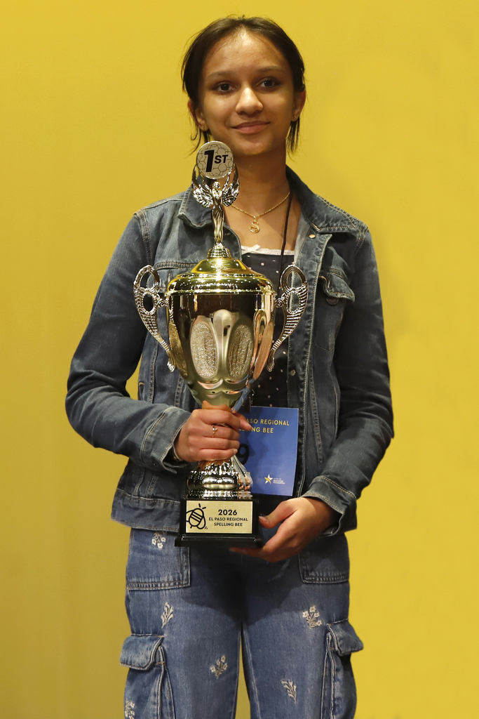 Shaheli De Silva, Young Women's STEAM Prep Academy smiles while holding spelling bee trophy