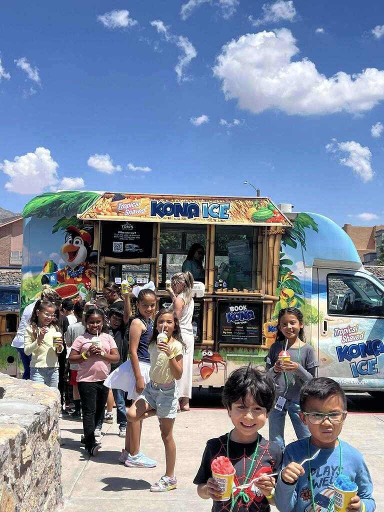 Kohlberg students smile in front of Kona Ice truck while holding sweet treats