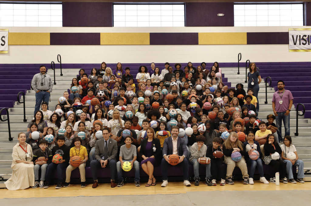Hartley PK-8 athletic programs, the Burges girls basketball team, A&A All the Way Foundation, alumni, and community members take group photo with Hartley PK-8 fifth graders