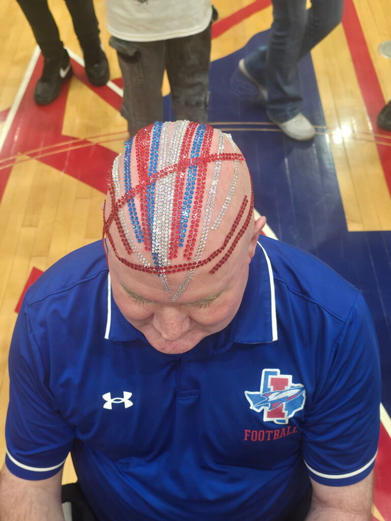 Photo of Irvin High School Principal Bobby Stives head bedazzled his head with silver, red, and blue gems