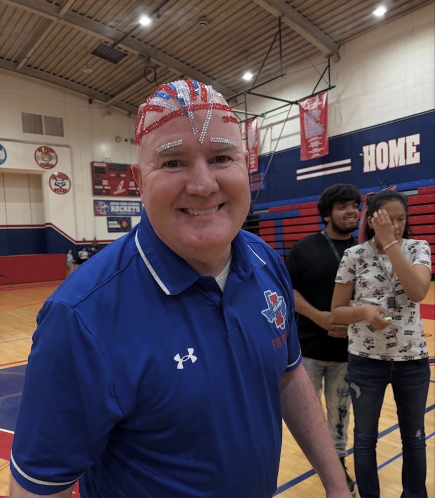 Irvin High School Principal Bobby Stives smiles after student bedazzle his head with silver, red, and blue gems
