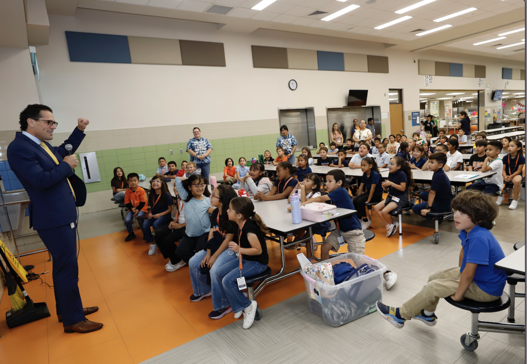 Superintendent Dr. Brian Lusk speaks to Don Haskins PK-8 students and staff in cafeteria