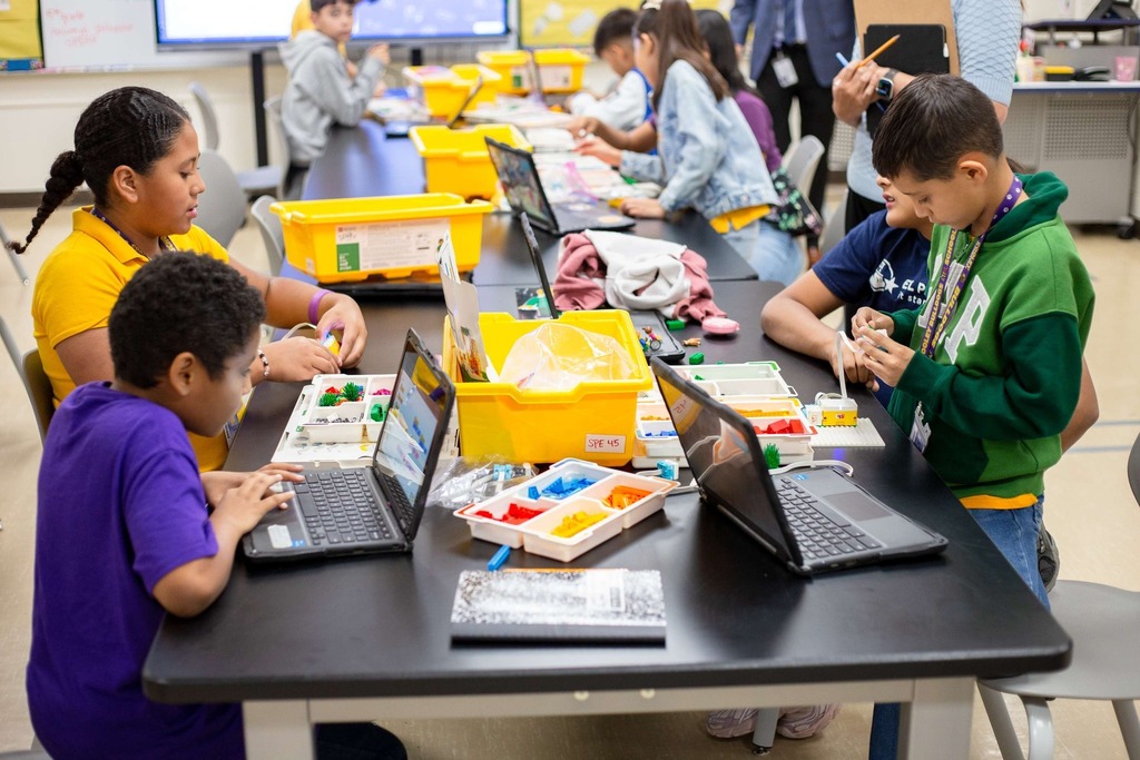 Students working with legos and laptops for class assignment