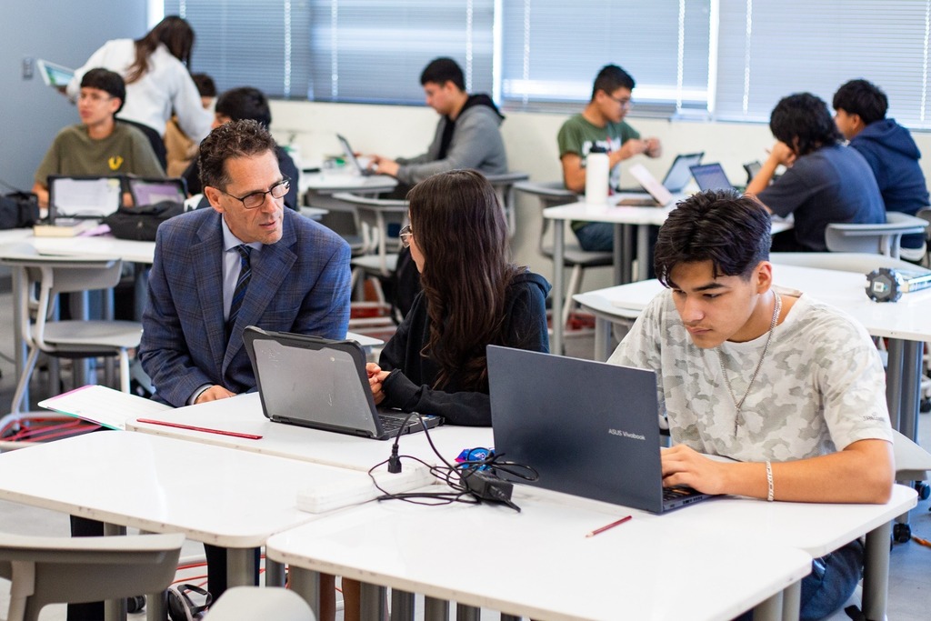 Superintendent Dr. Brian Lusk talking to a student in class