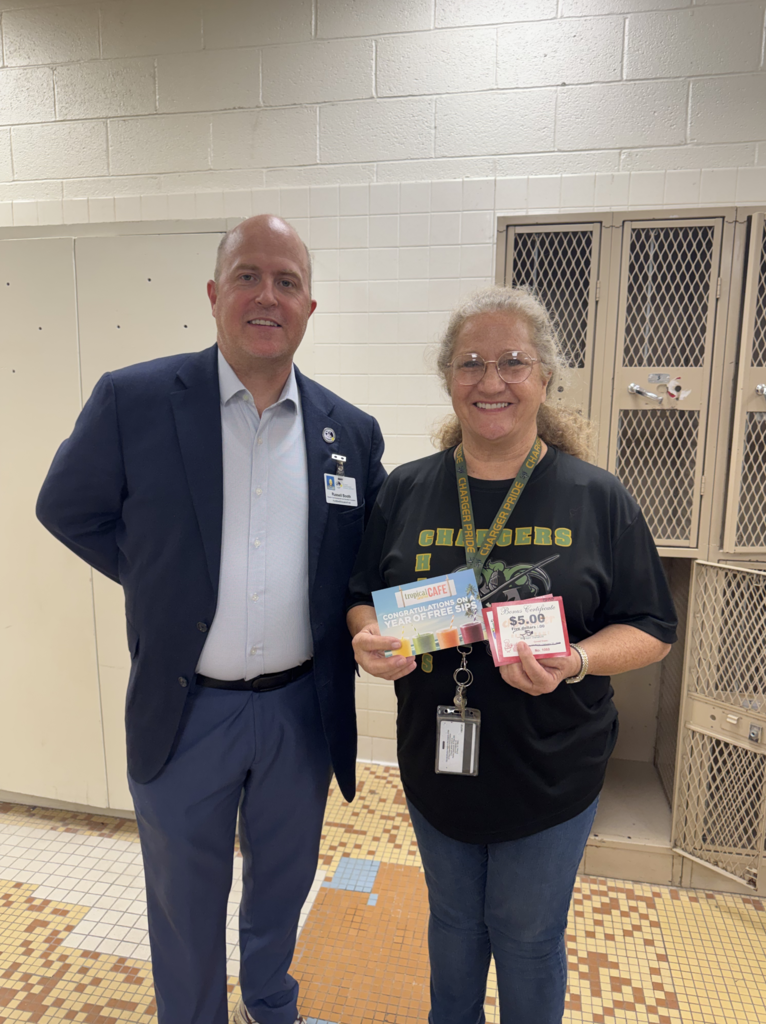 Attendance Challenge Charles Middle School Staff winner takes photo with prize and education foundation manager Russel Booth