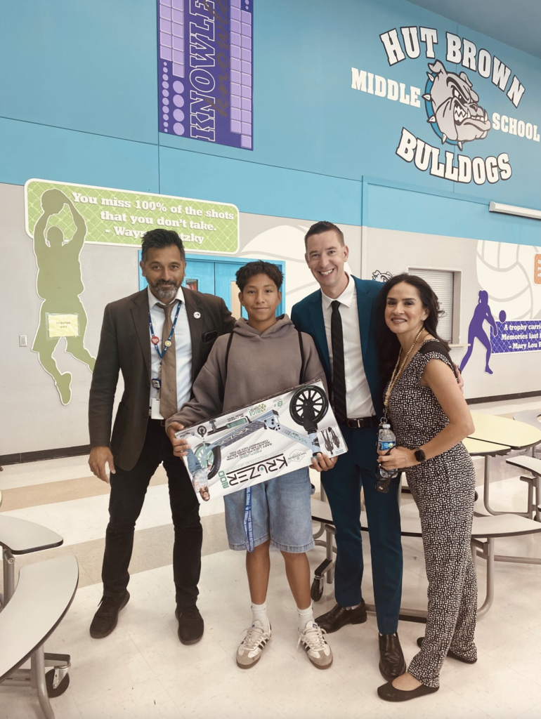 Attendance Challenge Student winner takes photo with prize  and staff