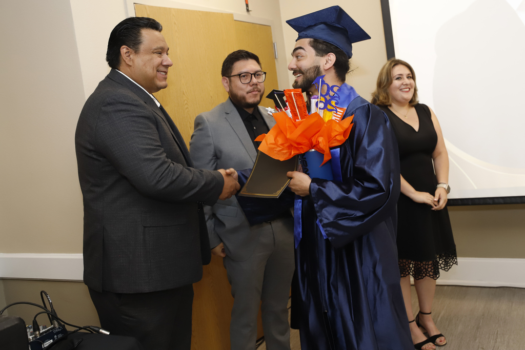 Project SEARCH graduates and El Paso ISD staff member shake hands