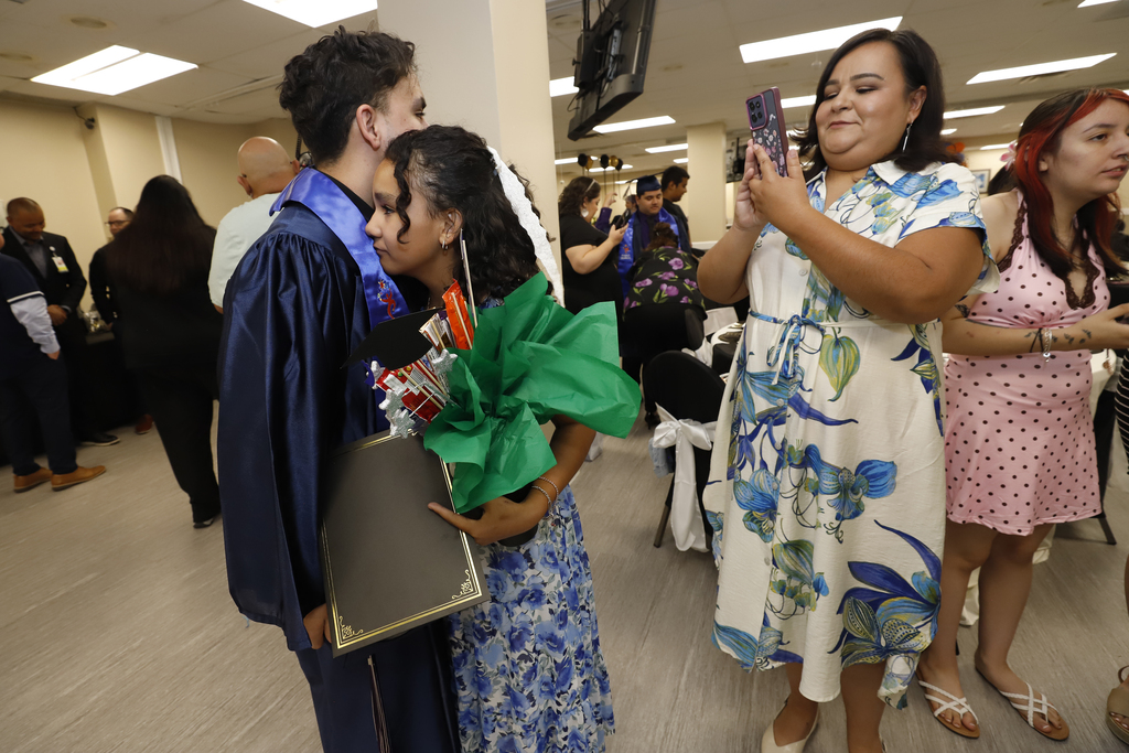 Project SEARCH graduates and family member hugging