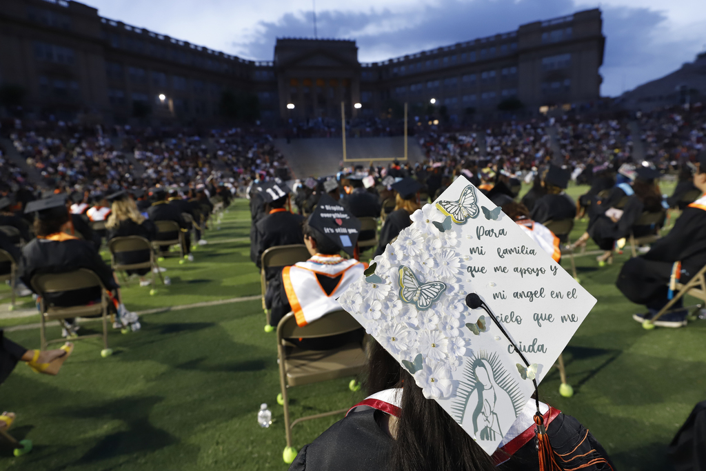 El Paso High School graduates sitting during graduation with view of school