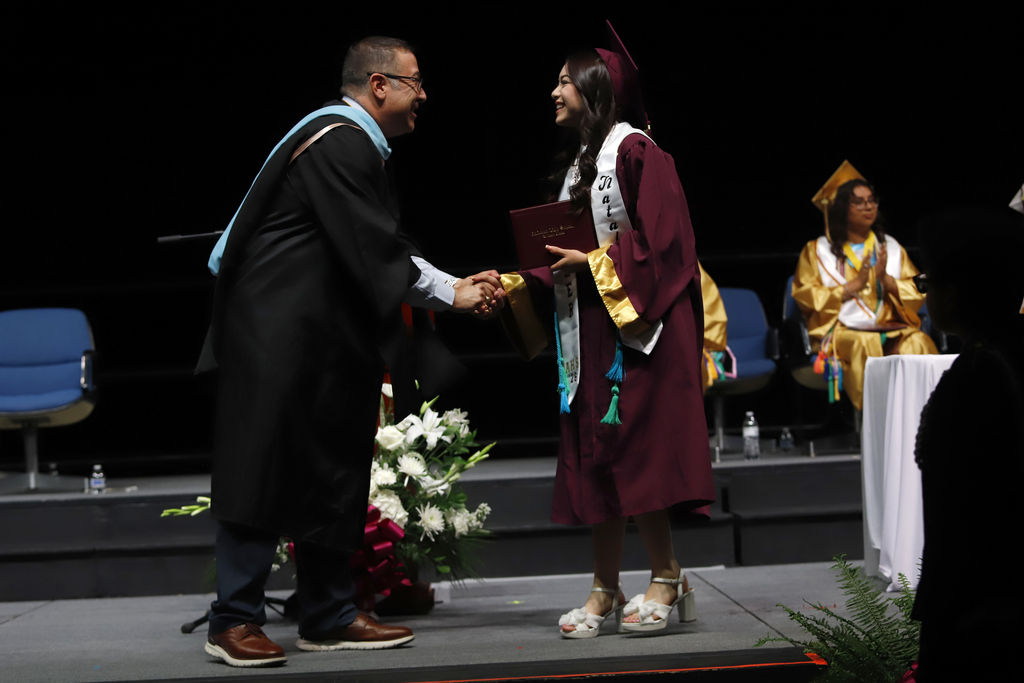 Andress principal shakes hand with student after they receive diploma