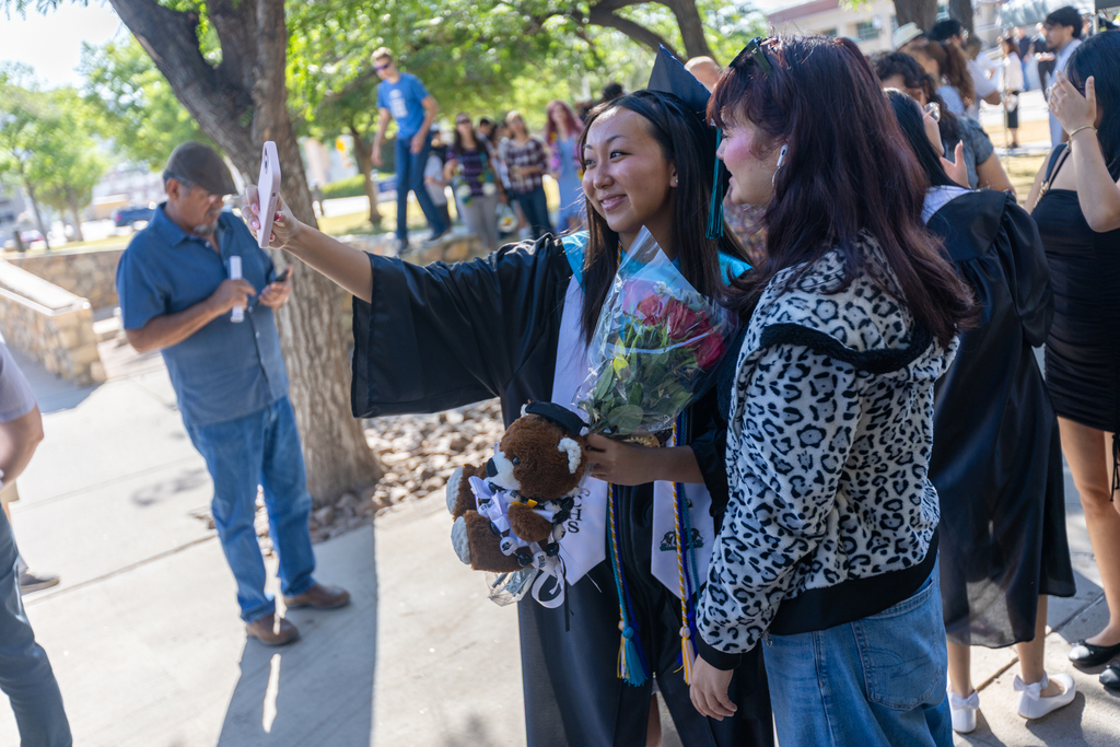 TMECHS grad takes photo with friend after graduation