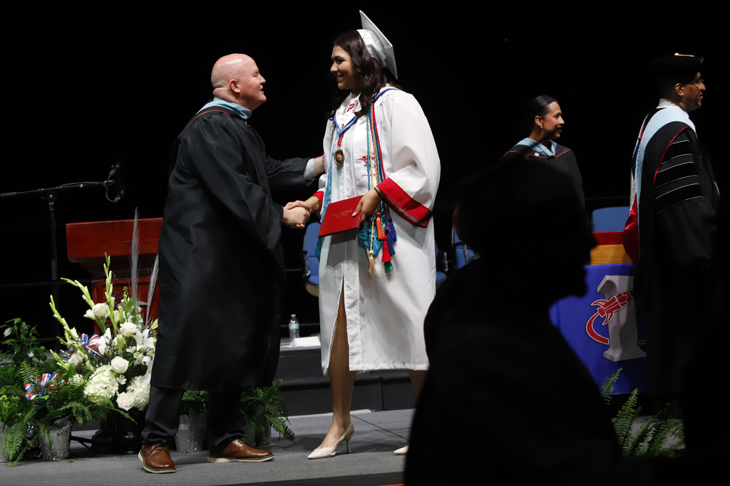 Irvin student shakes principal's hand after receiving diploma