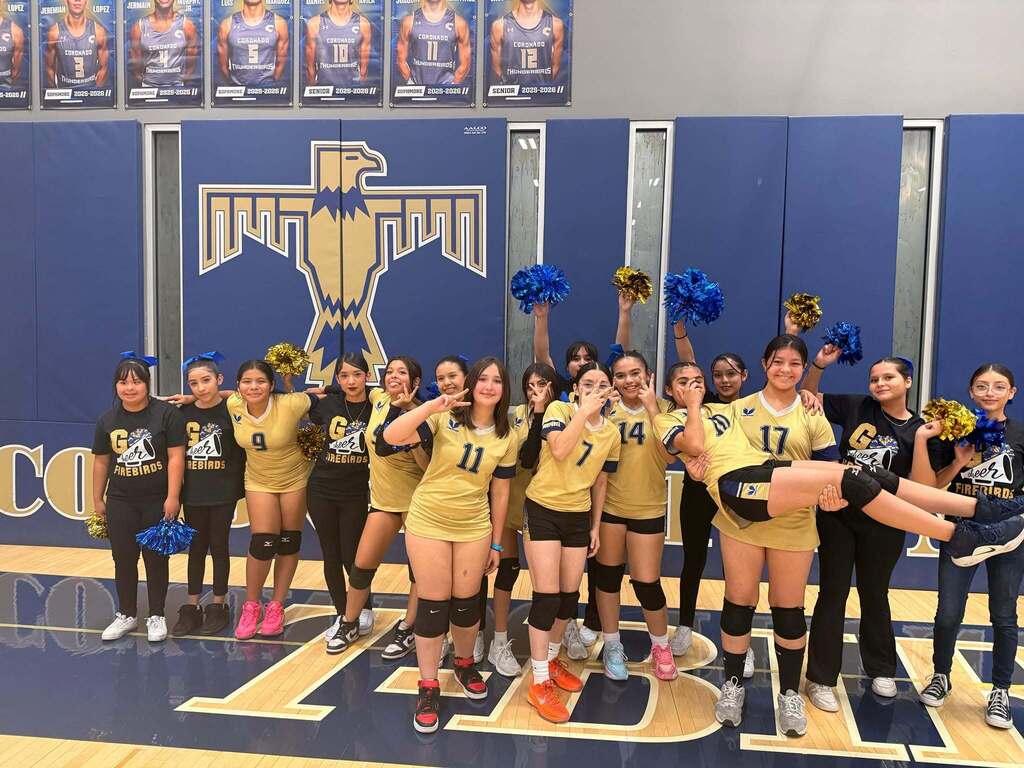 Murphree volleyball team and cheerleaders smile for a photo